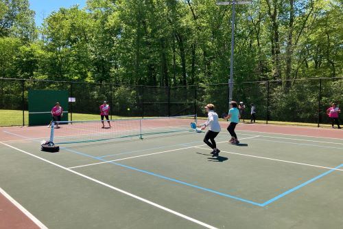 Four women playing pickleball