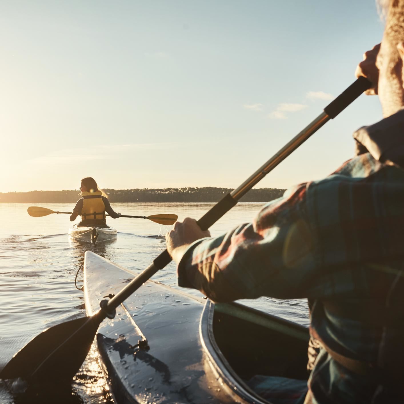 Man and woman kayaking at sunset