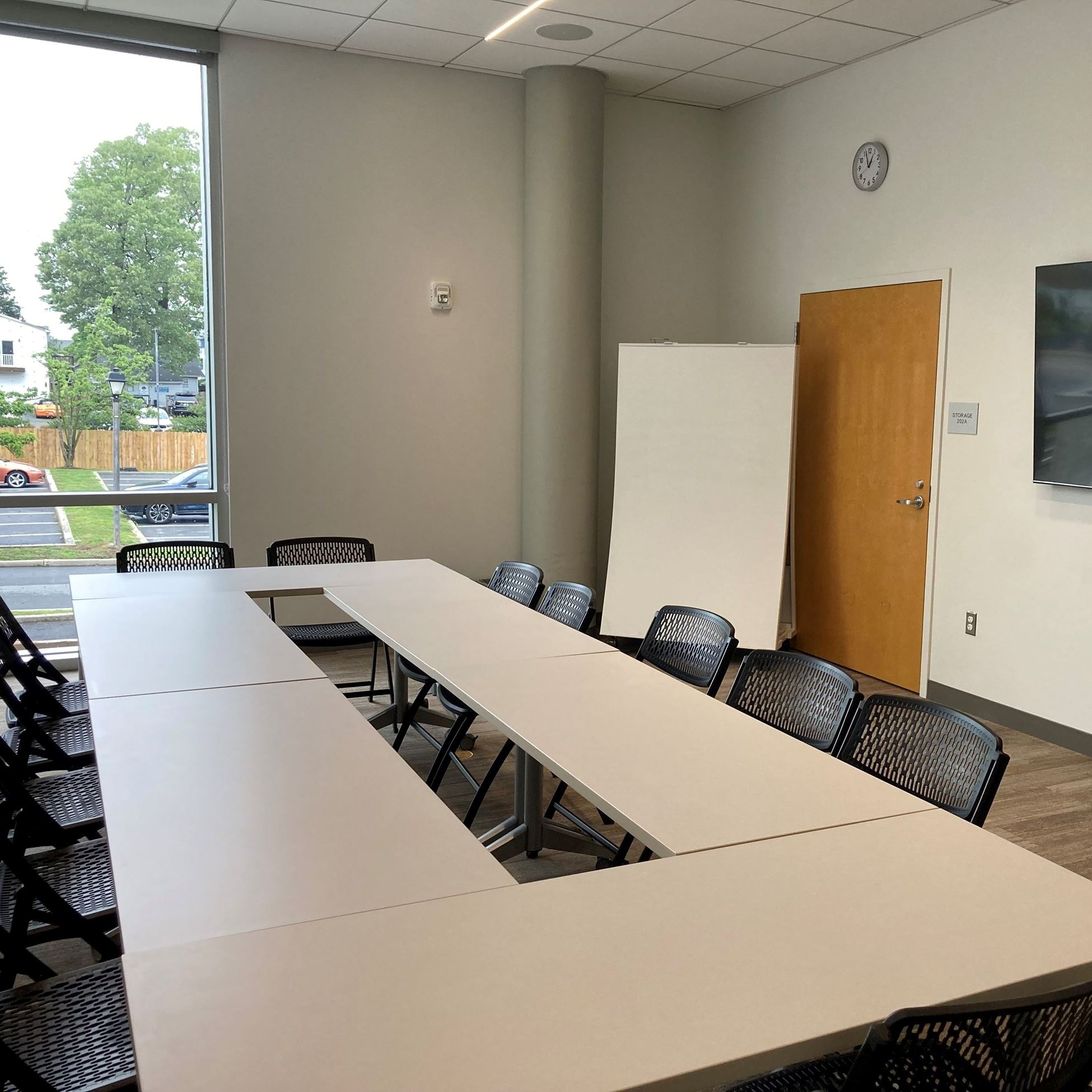 room with long white meeting table surrounded by black chairs