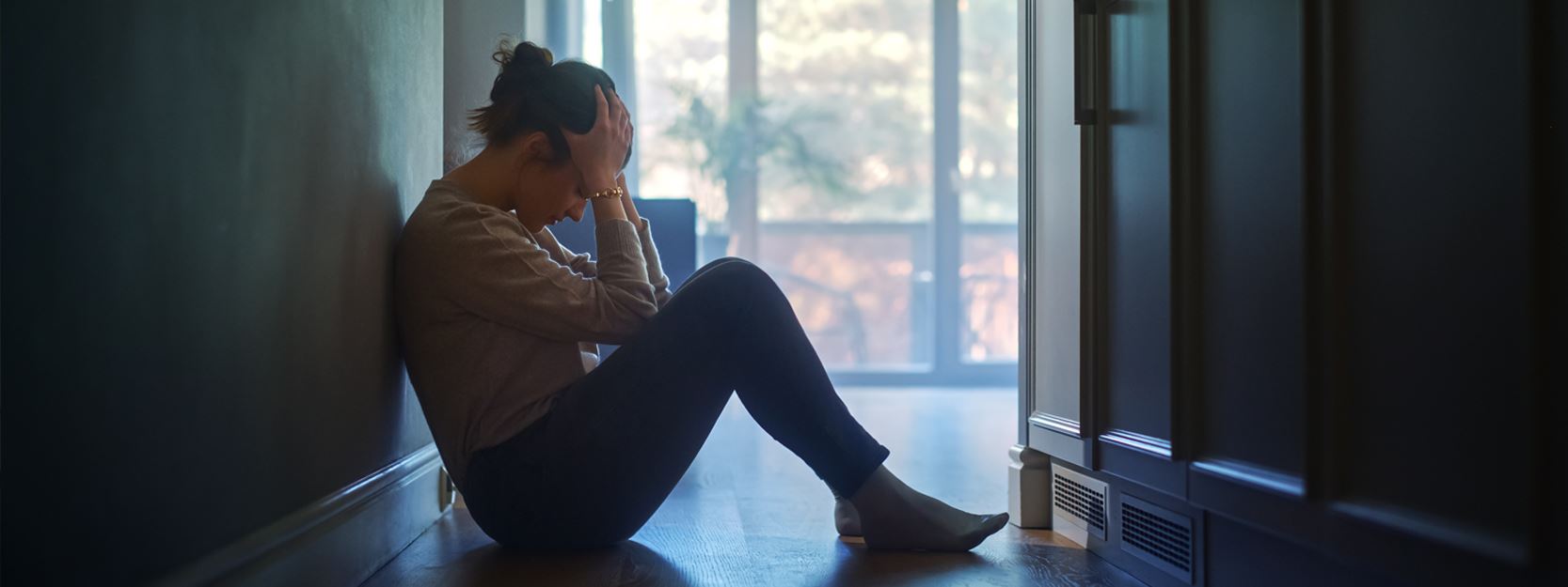 woman sitting on the ground with her head in her hands