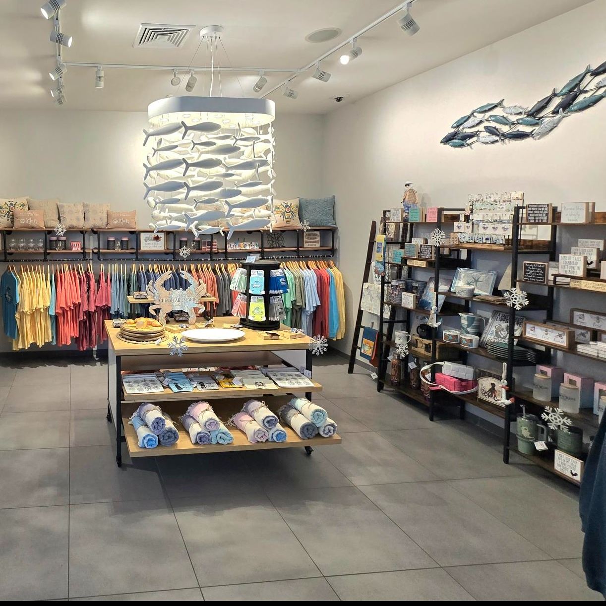 store interior with shelves and racks of tee shirts candles towels and other accessories